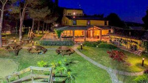 A building with a patio area, outdoor seating, and a pathway leading to the entrance. - Comfortable Cottages in Loro Ciuffenna (Terranuova Bracciolini)