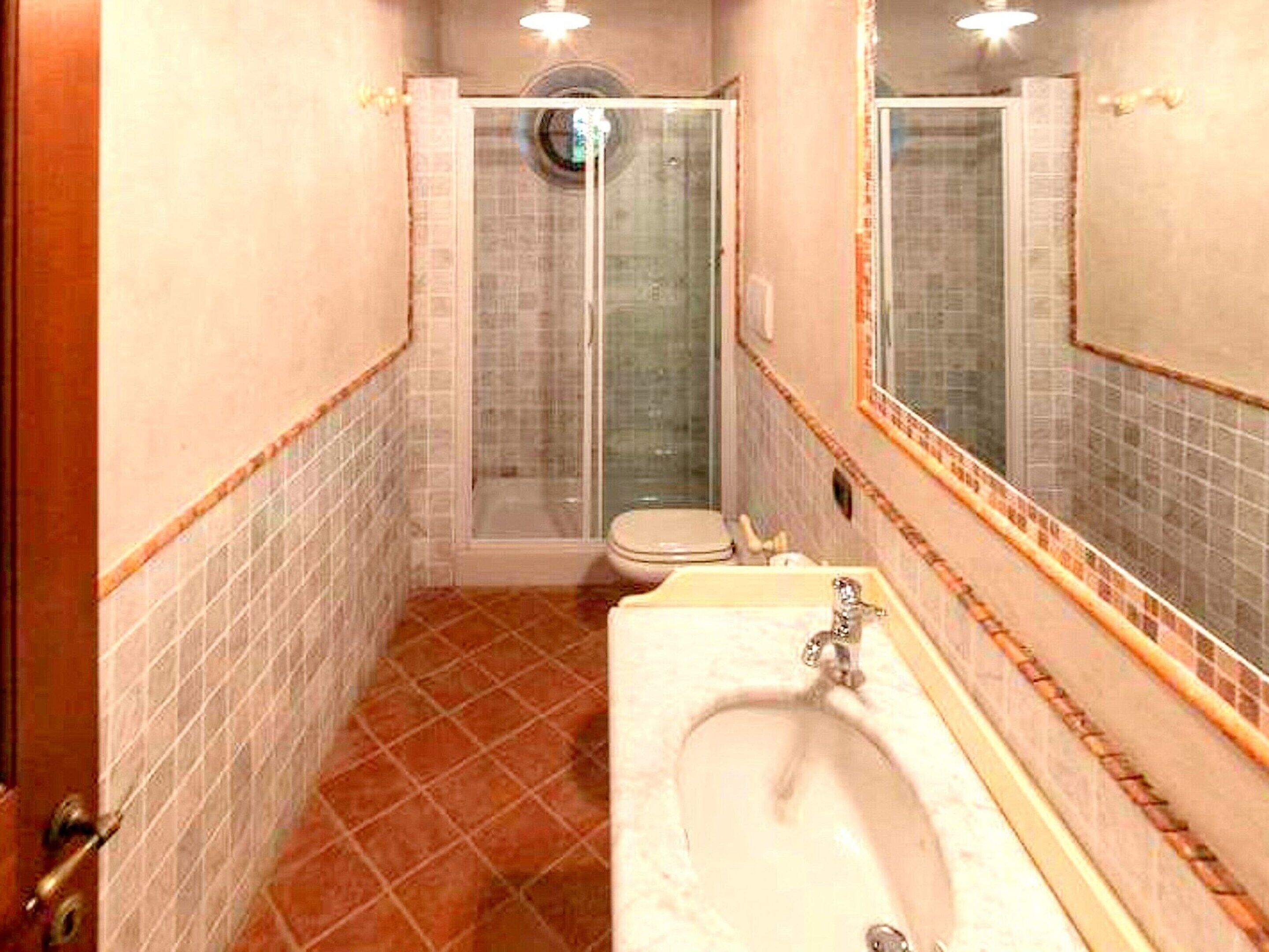 Une salle de bain avec douche, toilettes et lavabo.