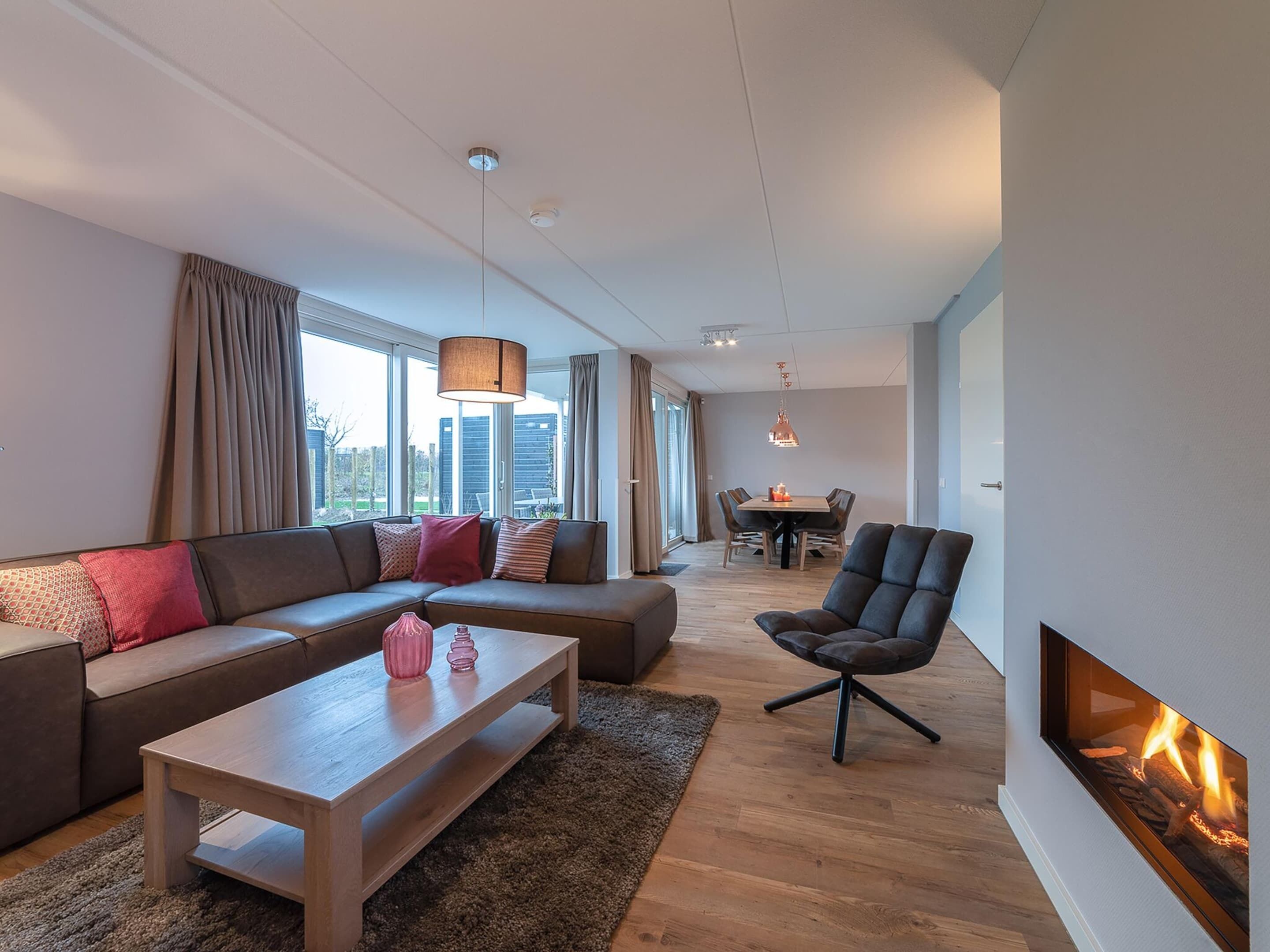 Una sala de estar moderna con sofá, mesa de centro y chimenea.