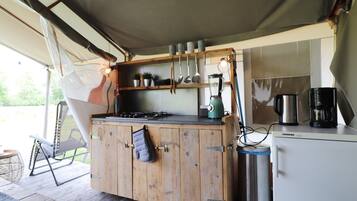 A kitchen with wooden cabinets, a gas stove, a coffee maker, and a refrigerator.