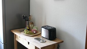 A kitchen counter with a toaster, a bottle of alcohol, a fruit platter, and a knife holder. - A Modern Holiday Home by the River Mosel (Moselkern)