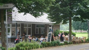 A cafe with outdoor seating, a sign indicating 'Elztal', and a menu board. - A Modern Holiday Home by the River Mosel (Moselkern)