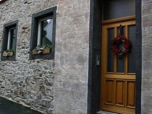 Un bâtiment en pierre avec une porte et des fenêtres en bois.