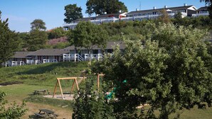 Zona residencial con casas, un parque infantil y mesas de picnic.
