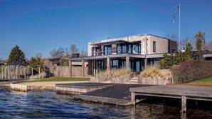 A modern building with a flat roof, large windows, and a flagpole. - Luxury Apartment in Residence Marina Kamperland - pet Friendly (Kamperland)