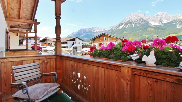 A wooden balcony with a bench, a wooden pergola, and a view of mountains and houses in the background. - Unique Chalet in the Center of Elmau Near Skilift (Ellmau)