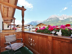 A wooden balcony with a bench, a wooden pergola, and a view of mountains and houses in the background. - Unique Chalet in the Center of Elmau Near Skilift (Ellmau)