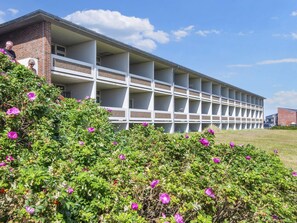 Un edificio de varios pisos con fachada de ladrillo y una serie de balcones.