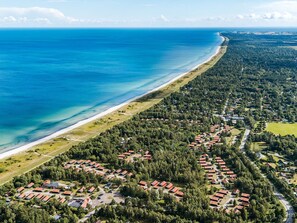 An aerial view of a coastal residential area with houses and a beach. - 6 Person Holiday Home on a Holiday Park in Vaeggerlose (Vaeggerlose)