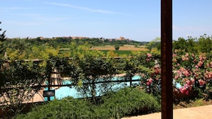 A covered outdoor area with a view of a swimming pool and greenery. - Chic Farmhouse in Montalto di Castro With Terrace (Montalto di Castro)