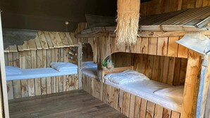 A rustic wooden room with bunk beds and a woven ceiling. - Quaint Holiday Home in Bievre in the Forest (Bievre)