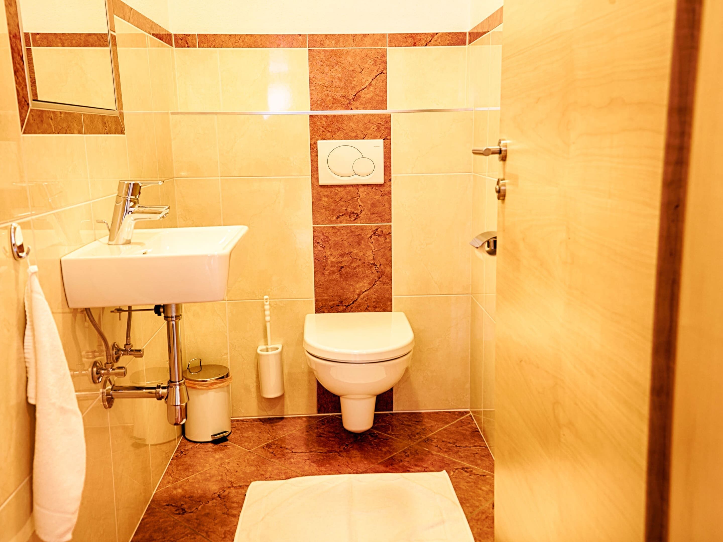 A bathroom with a sink, toilet, and a towel rack.