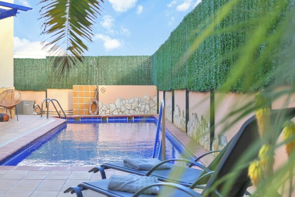 A swimming pool with lounge chairs, a stone wall, and a green hedge. - CASA MAY , LUXURY VILLA
UNIQUE ONE OFF MOROCCAN VILLA
5 STARS on Tripadvisor (Corralejo)