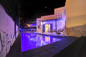 A nighttime pool area with a clear view of the pool, lounge chairs, and a building with a stone facade. - CASA MAY , LUXURY VILLA
UNIQUE ONE OFF MOROCCAN VILLA
5 STARS on Tripadvisor (Corralejo)