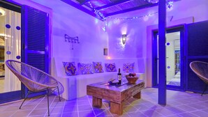 A cozy room with a wooden table, two wicker chairs, a decorative wall, and a string of lights. - CASA MAY , LUXURY VILLA

 UNIQUE ONE OFF MOROCCAN VILLA

5 STARS  on Tripadvisor (Corralejo)