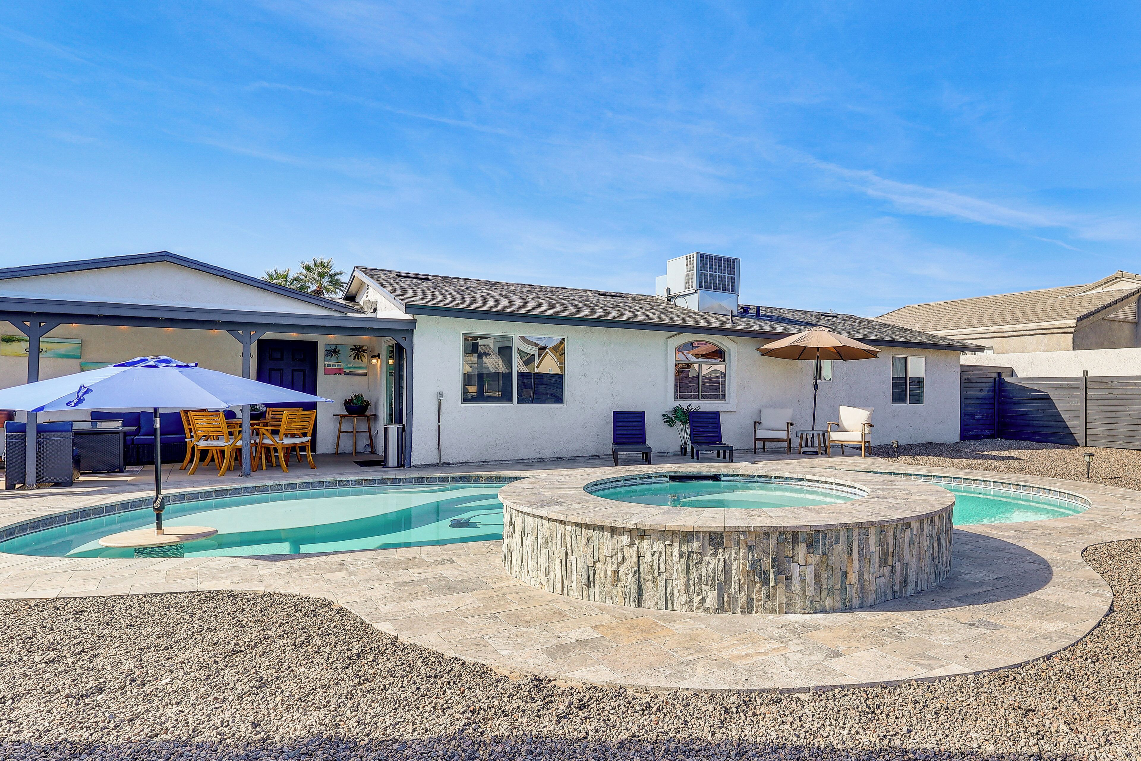 A house with a swimming pool, patio furniture, and a covered outdoor area.