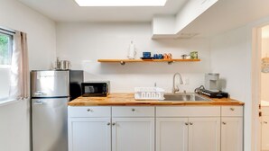 A compact kitchen with a refrigerator, microwave, sink, and wooden countertop. - Daytona Beach Studio: Walk to Boardwalk + Pier! (Daytona Beach)