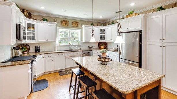 A modern kitchen with white cabinetry, a granite countertop island, and stainless steel appliances. - Georgia Countryside Home: 3 Mi to Wild Adventures! (Valdosta)