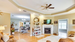 A spacious living room with a fireplace, a ceiling fan, and a dining area in the background. - Georgia Countryside Home: 3 Mi to Wild Adventures! (Valdosta)