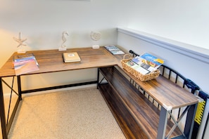 A corner room with a wooden desk, a bench, and a basket of magazines. - 4 Mi to Beach: Lewes Townhome w/ Ping-pong Table (Rehoboth Beach)