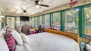 Une chambre d’hôtel avec un grand lit, un bureau, une chaise et une vue sur l’extérieur.