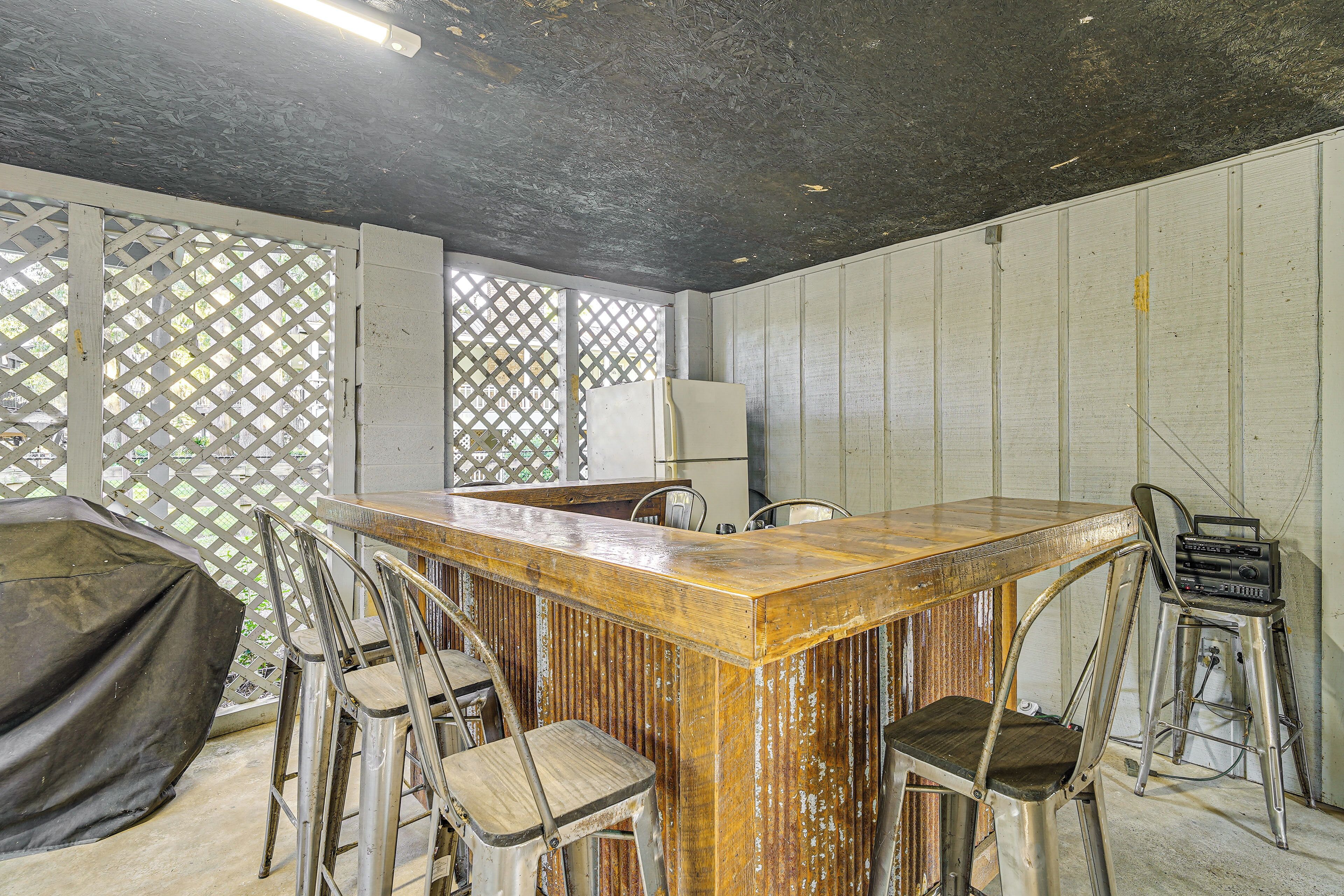 Eine Bar mit Holztresen, Metallhocker und einem Radio.