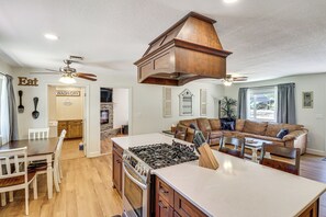 A spacious kitchen with a central island, wooden cabinets, and a built-in stove. - Near Woodland Lake Park: Home w/ Fire Pit! (Lakeside)