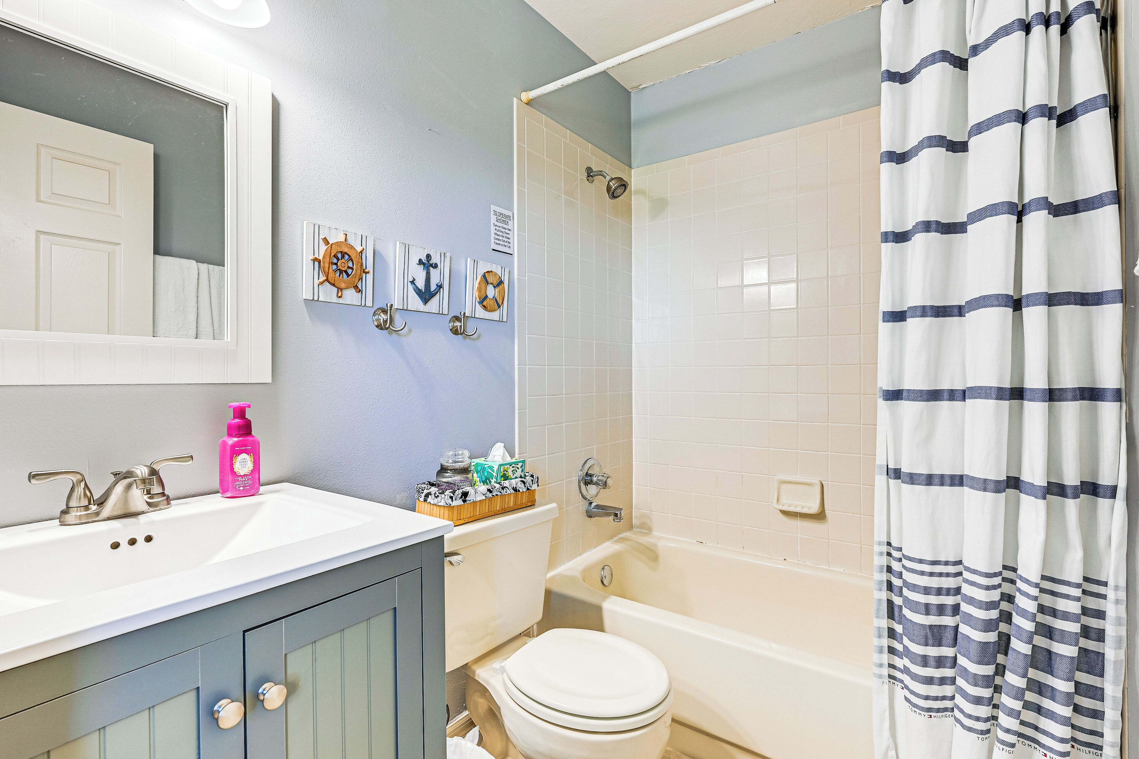 A bathroom with a white sink, a toilet, a bathtub, and a shower curtain.