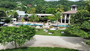 Un complexe hôtelier doté de plusieurs piscines, d’espaces de détente et d’une végétation luxuriante.
