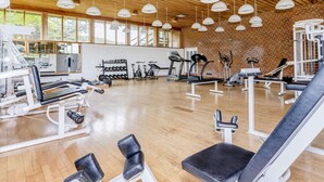 A spacious gym with various exercise equipment, large windows, and a wooden ceiling. - 6 Person Holiday Home on a Holiday Park in Hanstholm (Hanstholm)