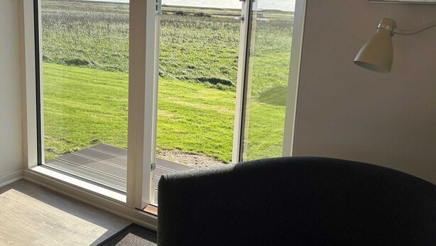 A room with a large sliding glass door leading to a grassy field. - 4 Person Holiday Home in Ribe (Ribe)