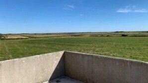 A concrete structure with a flat roof, surrounded by open fields and a clear sky. - 4 Person Holiday Home in Ribe (Ribe)