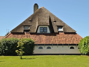 Ein traditionelles Haus mit einem steilen Satteldach, einem Schornstein und Ziegeldach.