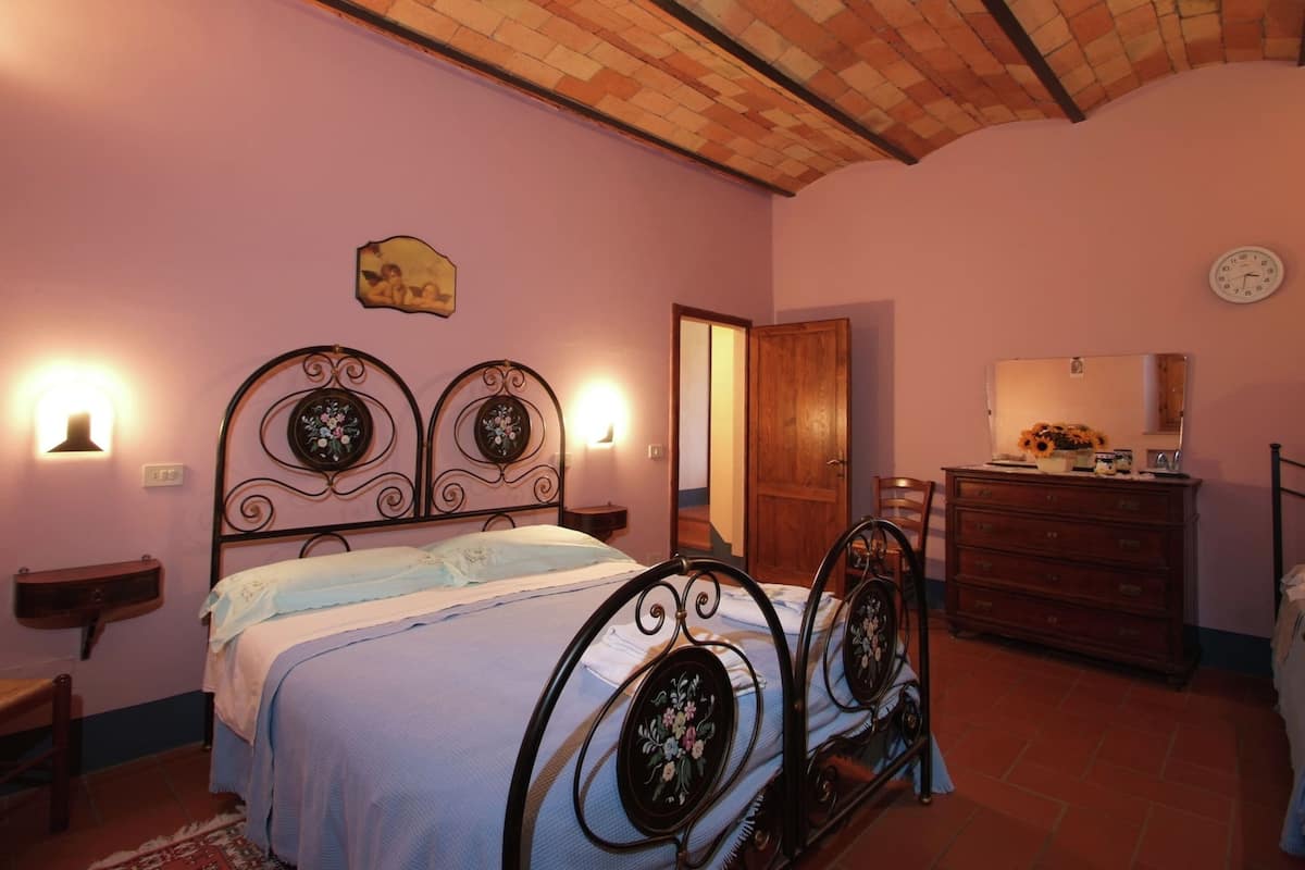 Un dormitorio con cama, cómoda y espejo.
