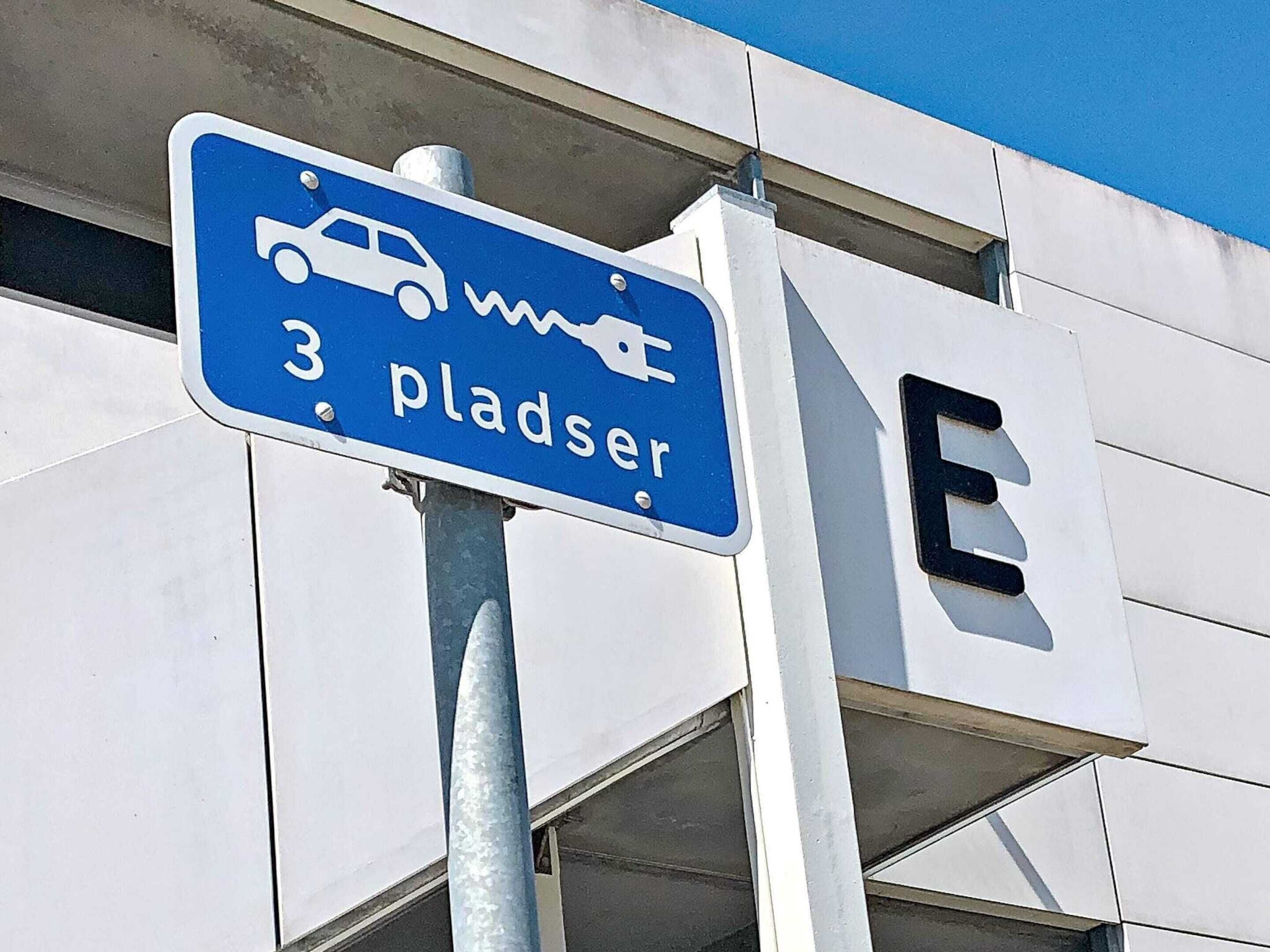 Un panneau de signalisation indiquant un espace de stationnement, avec un symbole de voiture et le chiffre 3.