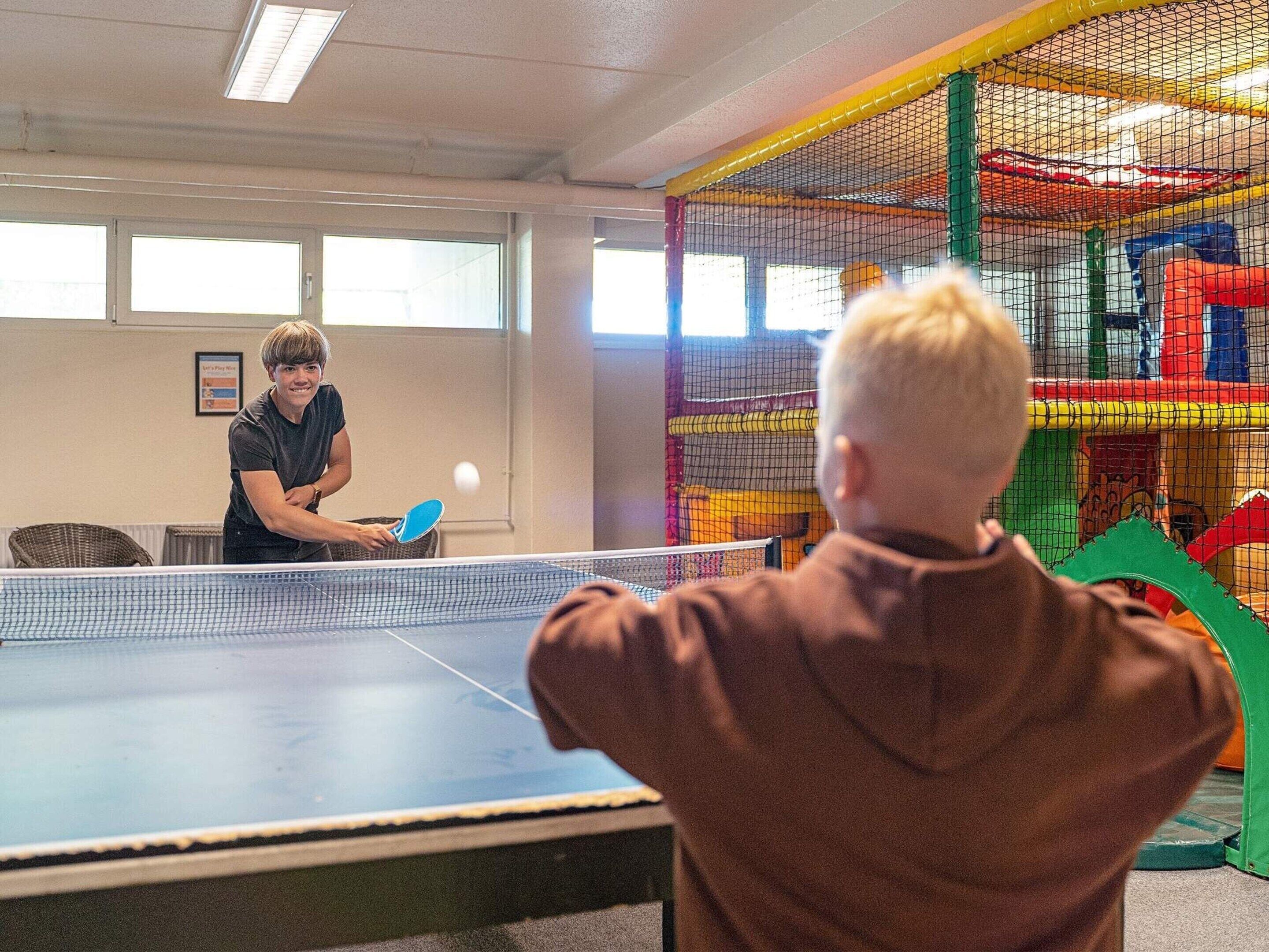 A table tennis game in progress with a net divider.