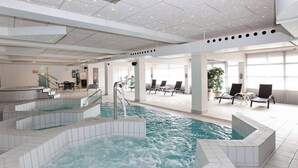 Ein Innenpool mit mehreren Ebenen und Sitzbereichen.