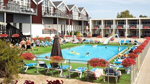 A pool area with lounge chairs and a diving board. - 5 Person Holiday Home on a Holiday Park in Glesborg (Glesborg)