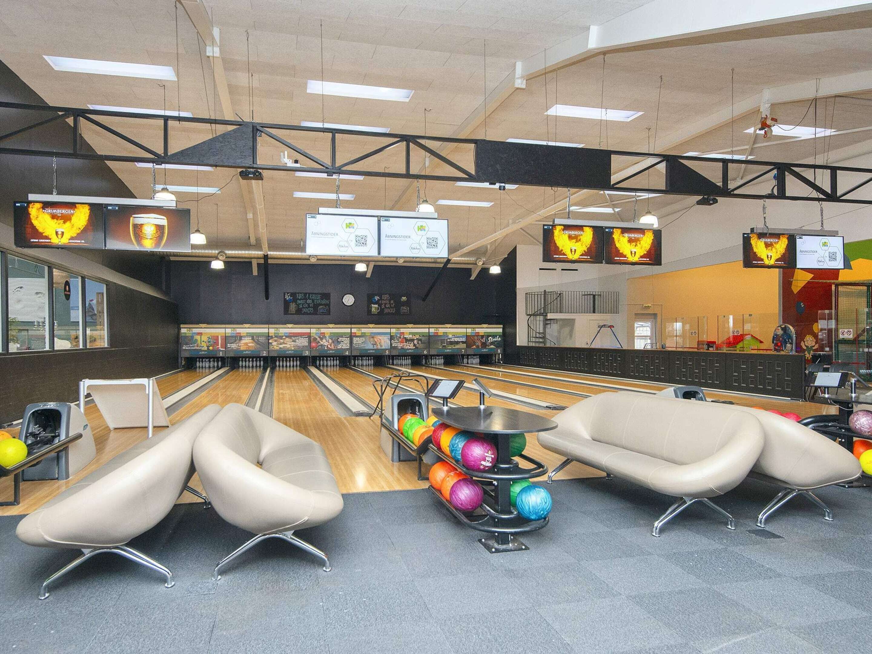 Un bowling doté de nombreuses pistes, de sièges modernes et d’un système d’affichage suspendu au plafond.