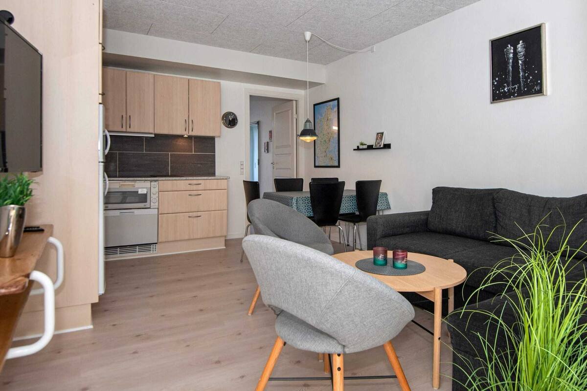 Un appartement moderne comprenant une cuisine, un coin repas et un salon.