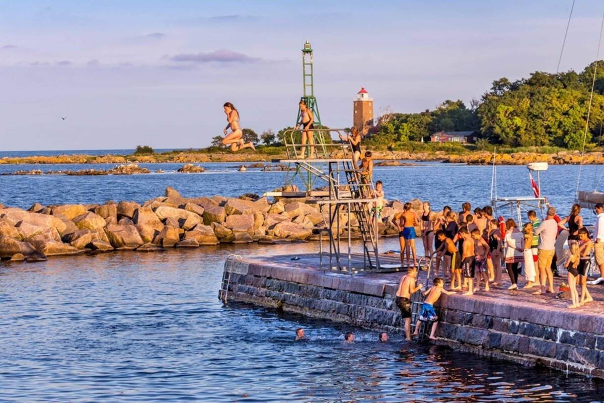 A pier with a lighthouse and rocky shoreline.