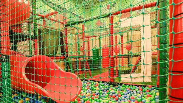 A play area with a red slide and a ball pit filled with multicolored balls.