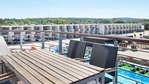 Een hotel met meerdere verdiepingen kamers, een zwembad en terras.