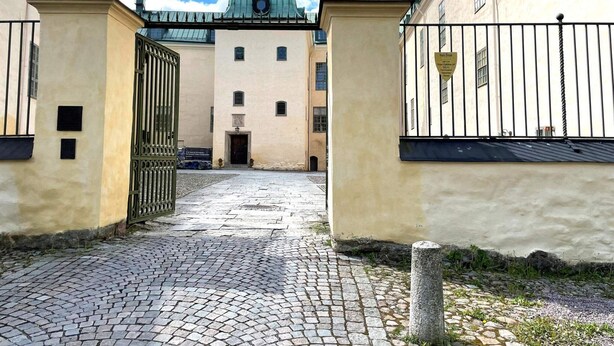 Un sentiero acciottolato che conduce a un edificio con una cupola e una torre dell'orologio.