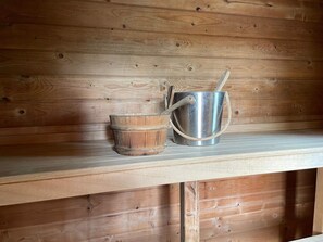 A wooden shelf with a metal bucket and a metal pot with a handle. - 5 Person Holiday Home in Ulrika (Ulrika)
