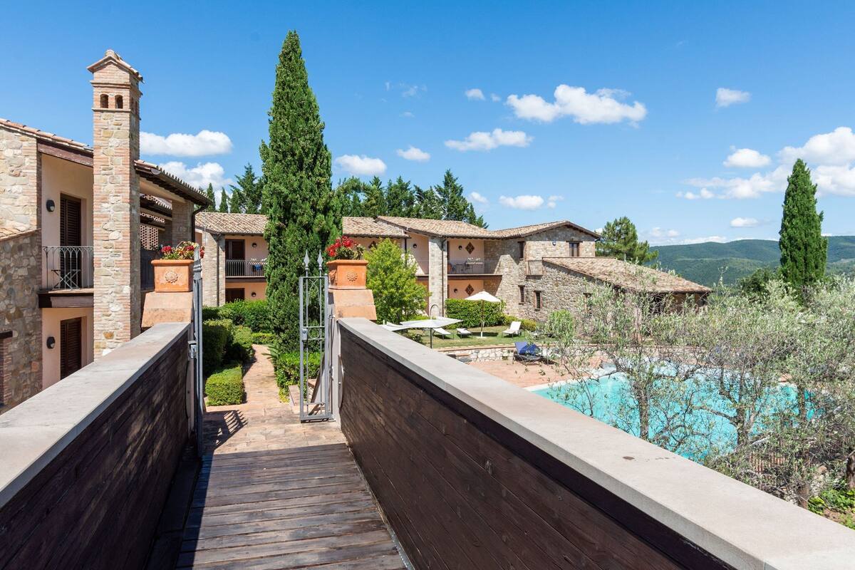 A resort with stone buildings, a wooden deck, and a pool.