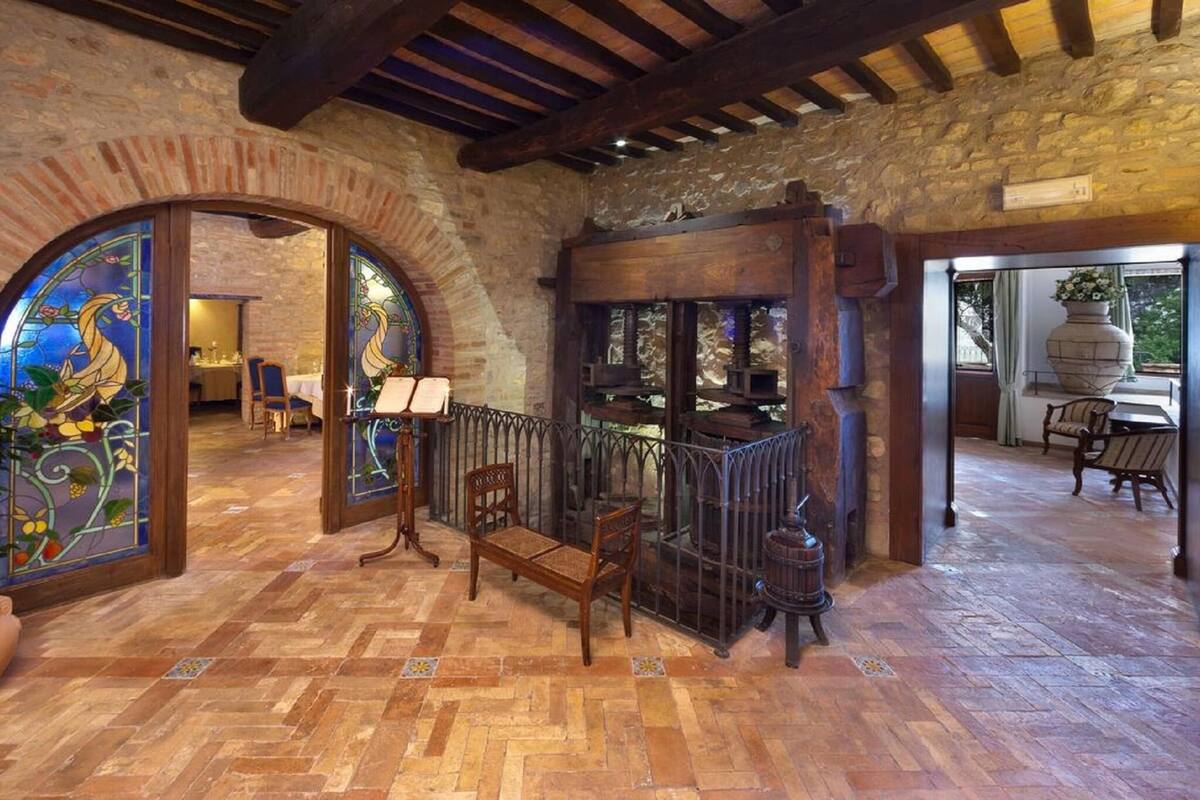 A rustic interior with a wooden bench, a piano, and a stained glass window.