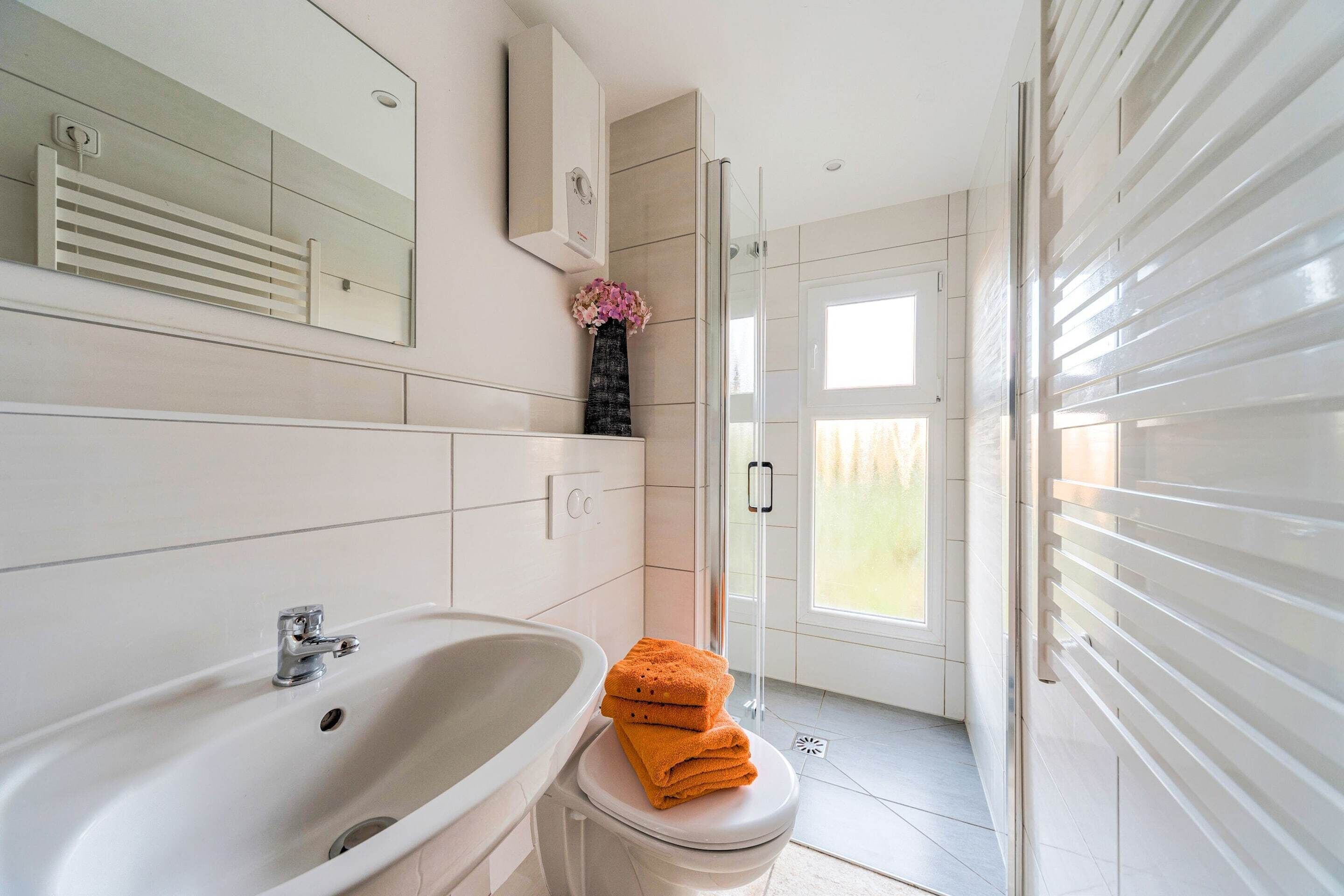 A bathroom with a bathtub, toilet, and a glass shower enclosure.