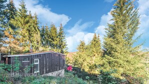 A rustic cabin with a stone foundation, surrounded by dense forest and tall trees. - Comely Holiday Home in Guntersberge Near Forest (Harzgerode)