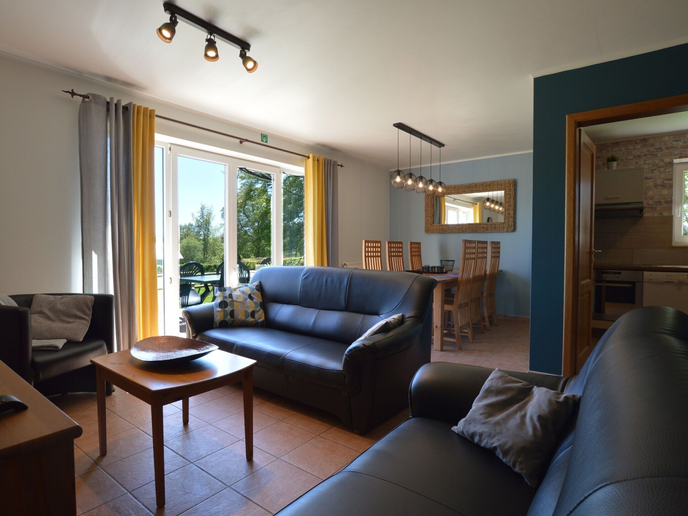 Un salon moderne avec un canapé, une table et un coin repas avec des chaises.